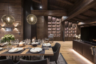 Closeup of the dining table set for dinner with TV at Nidus Apartment in Lech