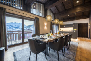 Dining table set for breakfast with view over Lech from the balcony at Nidus Penthouse in Lech