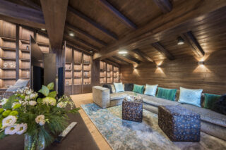 Sofas and sideboard with flower vase, and twin flat screen TVs at Nidus Penthouse in Lech