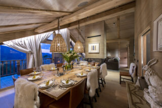 Dining area in the evening with table set for dinner at Chalet la Loze in Méribel