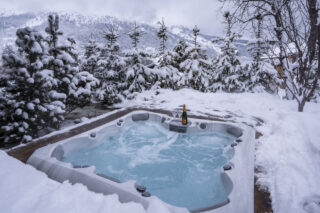 Outdoor hot tub in snow-covered garden at Chalet la Loze in Méribel
