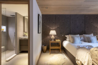 Bed and en suite shower room in bedroom four at Chalet la Loze in Méribel