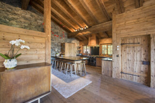 Breakfast bar and kitchen with door leading to side balcony at Chalet Bibi in Verbier