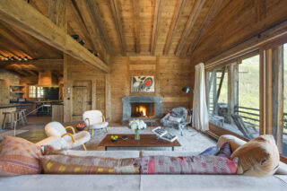 Open fireplace with stone surround in the lounge at Chalet Bibi in Verbier