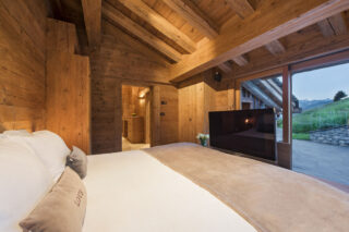 TV at foot of bed in master bedroom at Chalet Bibi in Verbier