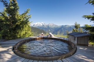Cedar outdoor hot tub set in circular deck at Chalet Bibi in Verbier