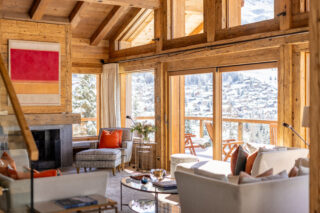 Corner armchair next to the fireplace in the living room at Chalet les Étrennes in Verbier