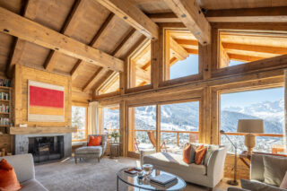 Living room with high ceilings and floor to ceiling windows at Chalet les Étrennes in Verbier