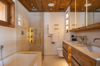 En suite bathroom with separate walk-in rain shower and twin sinks at Chalet les Étrennes in Verbier