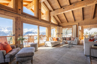 High ceiling and floor-to-ceiling windows opening to balcony at Chalet les Étrennes in Verbier