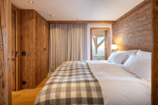 Bedroom one with terrace access at Chalet Pierrier in Verbier