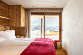 Bedroom three with French doors to terrace and outdoor hot tub at Chalet Pierrier in Verbier