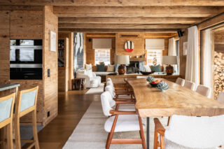Dining table with adjacent kitchen in the daytime at Chalet Pierrier in Verbier