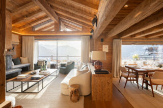 Lounge and dining area with sunlit mountain views at Chalet Pierrier in Verbier