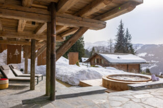 Garden level terrace with loungers and hot tub at Chalet Pierrier in Verbier