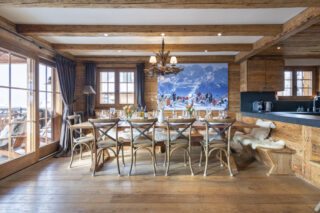 Dining table and kitchen at Apartment Silver in Verbier