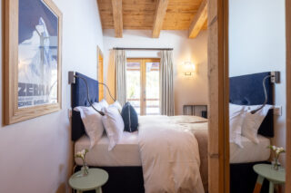 Bedroom four with doors to balcony at Chalet Sirocco in Verbier