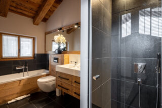 Bedroom three e suite bathroom with twin sinks and shower in at Chalet Sirocco in Verbier