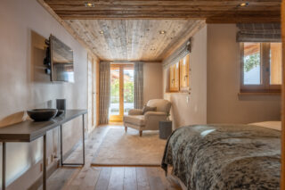 Lounge area and TV with doors to terrace in bedroom two at Chalet Sirocco in Verbier