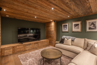 Cinema room with large flat screen TV and L-shaped sofa at Chalet Sirocco in Verbier