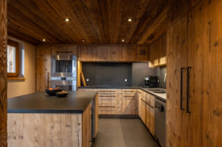 Kitchen with wood-panelled cabinets at Chalet Sirocco in Veriber