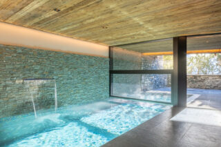 Indoor-outdoor swimming pool with cascade at Chalet Sirocco in Verbier
