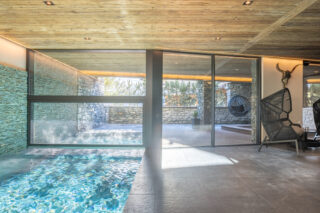 Indoor-outdoor swimming pool in the spa area at Chalet Sirocco in Verbier