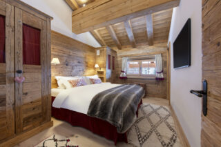Double bedroom two with wall-mounted TV at Penthouse Treize Etoiles in Verbier