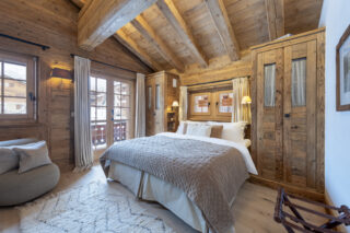 Double bedroom three with balcony access at Penthouse Treize Etoiles in Verbier