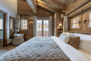 Double bedroom three with French doors opening to balcony at Penthouse Trize Etoiles in Verbier