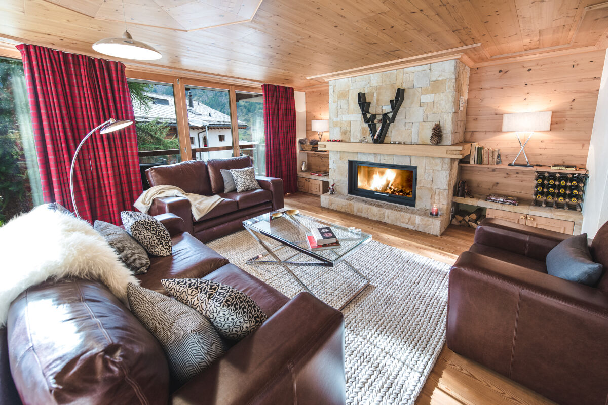 Sofas and armchair around the fireplace in the living area at Apartment d'Amore in Zermatt