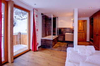Bedroom 2 open ensuite bathroom and balcony at Chalet Gemini in Zermatt