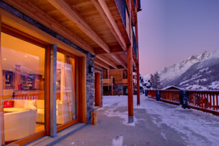 Terrace at Chalet Gemini in Zermatt with view into living area through French windows