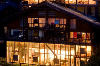 Night time view though the windows of the living space at the Heinz Julen Loft in Zermatt