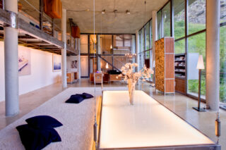 Lowered suspended table surrounded by rugs and cushions at the Heinz Julen Loft in Zermatt