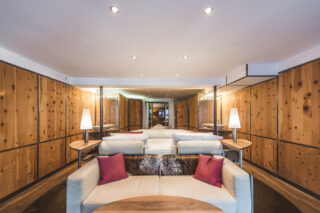 Seating area and double bed in the master bedroom suite at the Heinz Julen Loft in Zermatt