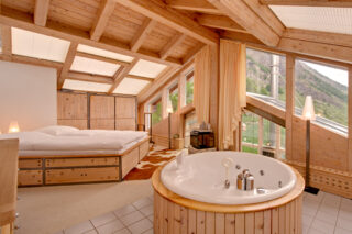MAster bedroom suite with circular freestanding bath tub at the Heinz Julen Penthouse in Zermatt