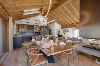 Dining table and kitchen at at Penthouse Weissmatten in Zermatt