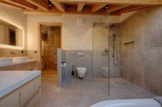 Walk-in shower and twin sinks in master bathroom at Penthouse Weissmatten in Zermatt