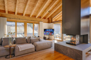 Fireplace, sofas and flat screen TV in living space at Penthouse Weissmatten in Zermatt