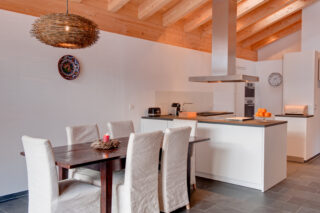 Dining table and kitchen at Penthouse Zeus in Zermatt