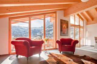 Armchairs in front of the windows and French doors leading to the balcony with view of the Matterhorn at Penthouse Zeus in Zermatt