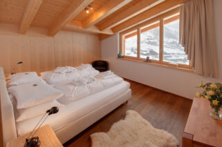 Bedroom two with view over Zermatt in the snow at Penthouse Zora in Zermatt