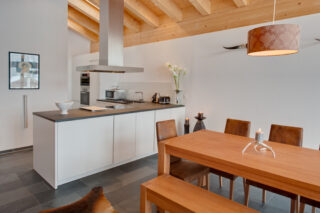 Modern open kitchen and dining table at Penthouse Zora in Zermatt