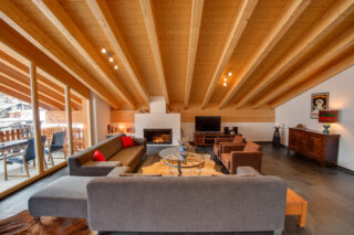 Lounge area with fireplace and TV at Penthouse Zora in Zermatt