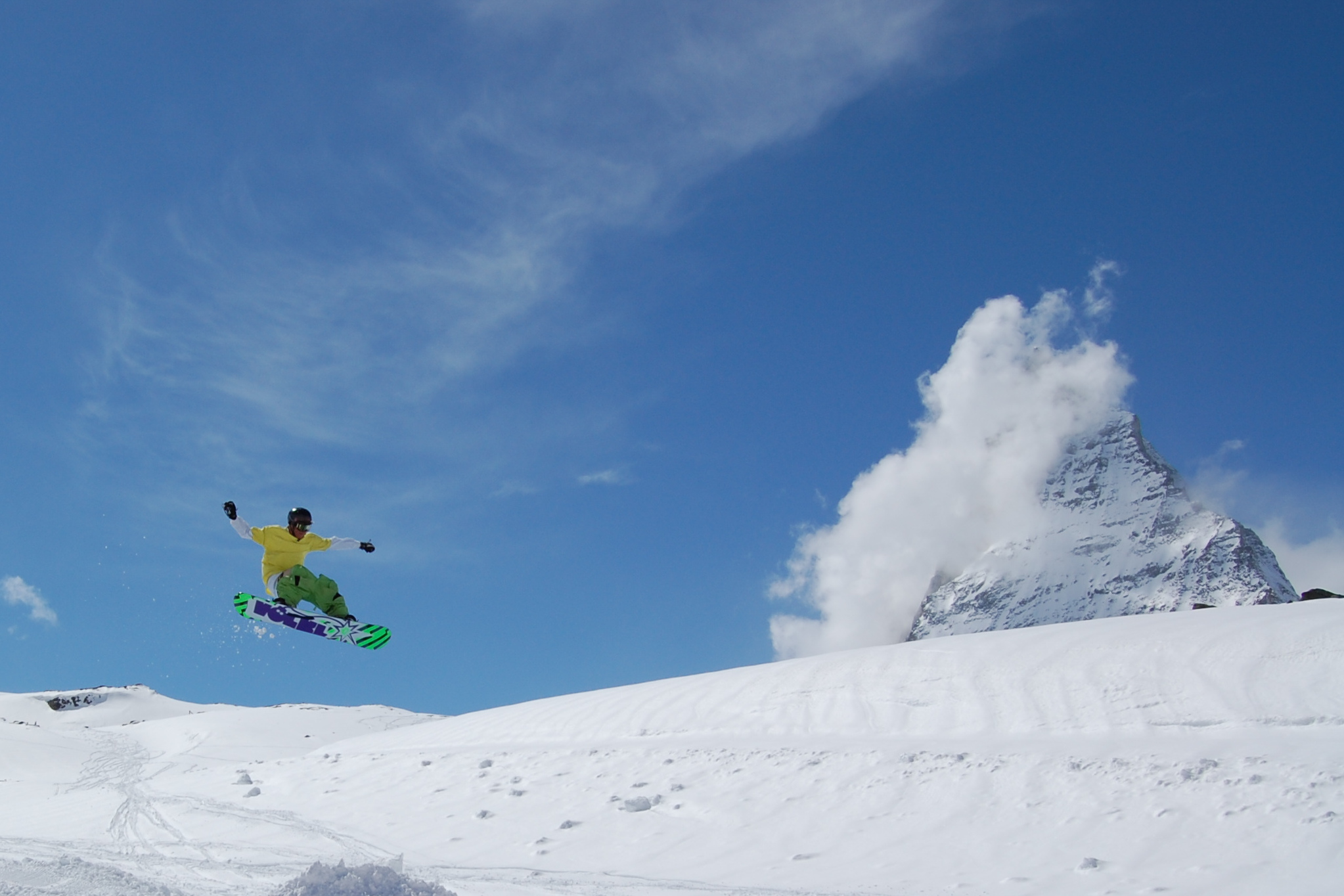 Snowboarder performing a trick with the Matterhorn in the background